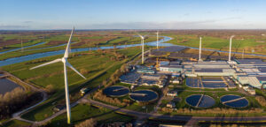 Luchtfoto van een zuivering met windmolens eromheen.